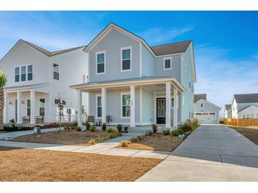 Two-story house with light blue siding, front porch, and driveway at 225 Witherspoon St, Summerville, SC 29486