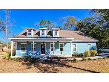Charming light blue house with a front porch and landscaped yard at 273 Plantation Ln, Walterboro, SC 29488