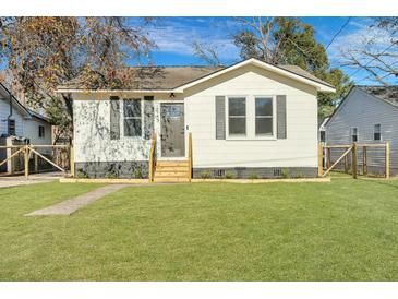 Newly renovated home with a white exterior, gray accents, and a landscaped lawn at 2943 Alabama Dr, North Charleston, SC 29405