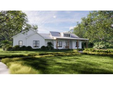 Charming farmhouse exterior with metal roof and landscaped lawn at 421 Sandridge Acres Trail, Holly Hill, SC 29059