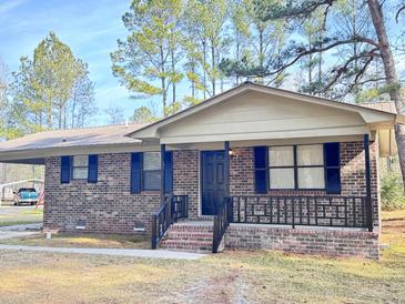 Brick ranch house with a covered porch, dark shutters, and a landscaped yard at 1401 Rivers St, Walterboro, SC 29488