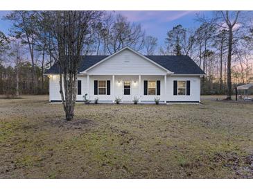 Charming one-story house with white siding, black shutters, and a covered porch at 326 Turner Ln, Round O, SC 29474