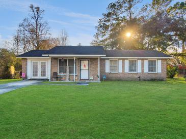 Brick ranch home with a spacious lawn and mature trees at 4443 Farmwood St, Ladson, SC 29456