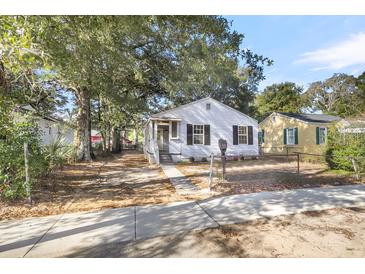 Charming white house with black shutters, a porch, and a landscaped yard at 2720 W Surrey Dr, North Charleston, SC 29405