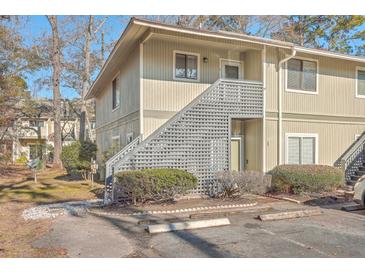 Tan colored building exterior with gray accents, landscaping, and parking at 2745 Jobee Dr # 205, Charleston, SC 29414