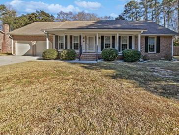 Brick ranch house with attached garage and landscaped lawn at 309 Mayfield St, Summerville, SC 29485