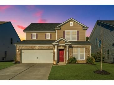 Two-story house with brick and siding, a double-car garage, and a manicured lawn at 394 Sanctuary Park Dr, Summerville, SC 29486