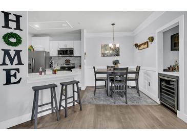 Open concept kitchen and dining area with stainless steel appliances and breakfast bar at 1300 Park West Blvd # 417, Mount Pleasant, SC 29466