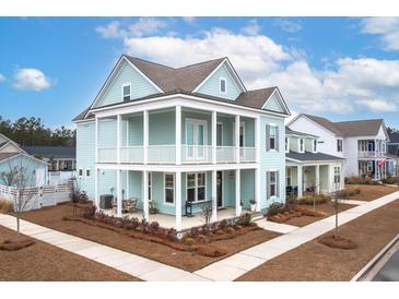 Two-story light teal house with white accents, front porch, and landscaped yard at 229 Symphony Ave, Summerville, SC 29486