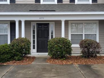 Tan house with white columns, black door, and landscaping at 8875 Jenny Lind St, North Charleston, SC 29406