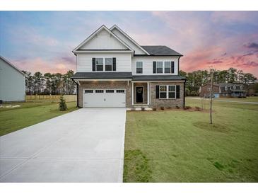 Two-story home with white siding, brick accents, and a large driveway at 117 Arabian Drive Lot B, Summerville, SC 29483