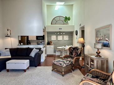 Bright living room with sectional sofa, ottoman, and wicker chairs, overlooking kitchen and dining area at 1481 Center Street Ext # 1808, Mount Pleasant, SC 29464