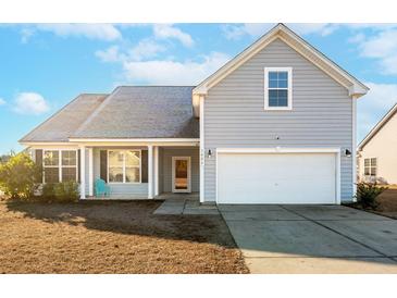 Gray house with a white garage door, porch, and landscaping at 3026 Gulfstream Ln, Ridgeville, SC 29472