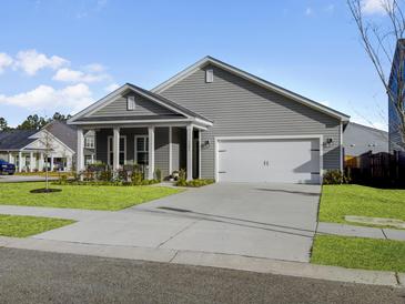 Gray house with white garage door and porch, landscaped lawn at 3206 Safe Harbor Way, Charleston, SC 29414