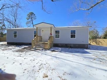 Newly constructed gray house with white accents, wooden stairs, and snowy front yard at 161 Stratton Dr, North Charleston, SC 29420