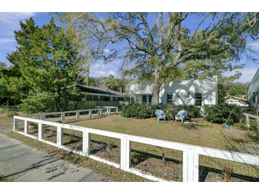 Charming home with a spacious front yard, large tree, and white fence at 186 Sans Souci St, Charleston, SC 29403