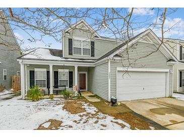 Two-story house with light green siding, white garage door, and a porch at 2005 Isabela Ct, Summerville, SC 29483