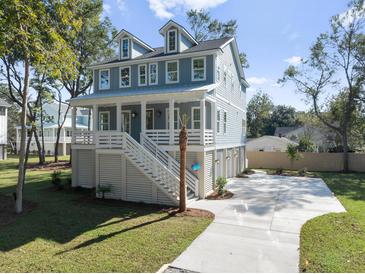 Two-story home with gray siding, white trim, and a detached garage at 3893 James Bay Rd, Johns Island, SC 29455