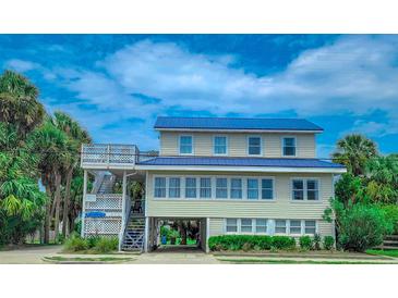 Two-story beach home with a metal roof and spacious deck at 209 Palmetto Blvd, Edisto Beach, SC 29438