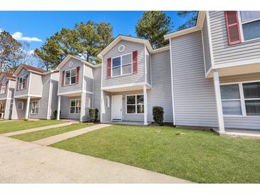 Gray townhouses with red accents and a well-maintained lawn at 517 Travelers Blvd, Summerville, SC 29485