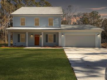 Two-story light blue house with a double garage and a manicured lawn at 1421 Brownswood Rd, Johns Island, SC 29455