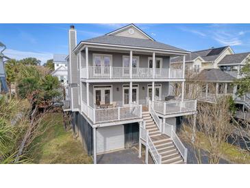 Two-story home with gray siding, multiple decks, and a detached garage at 209 Charleston Blvd, Isle of Palms, SC 29451