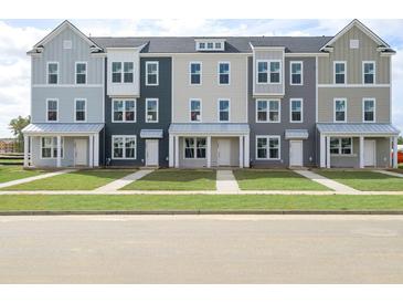 Front view of three-story townhomes with neutral siding and landscaping at 210 Yorkshire Dr # 6, Moncks Corner, SC 29461