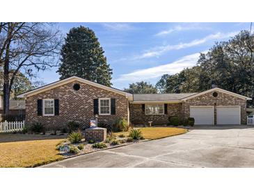 Brick ranch house with 2-car garage, landscaped yard, and white picket fence at 2383 Erskine Ct, Charleston, SC 29414