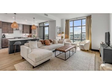 Bright living room with comfy sectional sofa, large windows, and city view at 5 Gadsdenboro St # 410, Charleston, SC 29401
