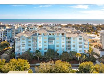Oceanfront community view, featuring a light blue building and lush landscaping at 5804 Palmetto Dr # A-405/407, Isle of Palms, SC 29451