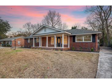 Brick ranch house with covered porch and landscaped yard at 1111 Barrett Rd, Charleston, SC 29407