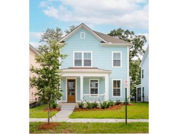 Charming light blue two-story house with a front porch and well-manicured lawn at 2253 Blue Bayou Blvd, Johns Island, SC 29455