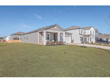 Gray house with white columns and a two-car garage, featuring a well-manicured lawn at 286 W Bradford Pointe Dr, Summerville, SC 29486