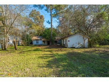 Overgrown backyard with two small structures needing renovation at 4230 Barnwell Ave, North Charleston, SC 29405