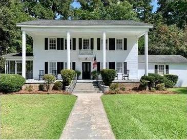 Two-story white house with columns, a walkway, and lush lawn at 109 Quaker Rd, Saint George, SC 29477