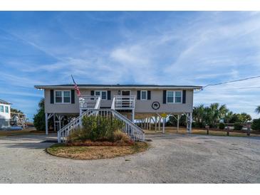 Elevated beach house with white stairs and American flag at 1308 Palmetto Blvd Blvd, Edisto Beach, SC 29438