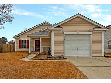 Beige house with a white garage door and landscaping at 139 Blue Jasmine Ln, Summerville, SC 29483