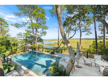 Inviting pool with wooden deck overlooking tranquil water views at 26 Cormorant Island Ln, Kiawah Island, SC 29455