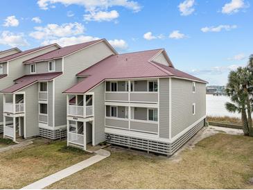 Two-story building with gray siding, red roof, and water views at 48 Mariners Cay Dr, Folly Beach, SC 29439