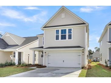 Two-story house with beige siding, white garage door, and landscaping at 733 Opal Wing St, Moncks Corner, SC 29461