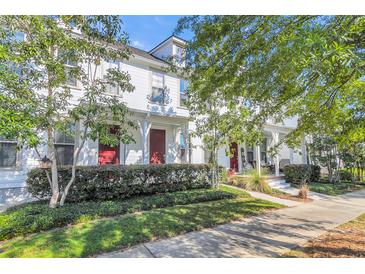 White two-story home with red doors, landscaping, and a sidewalk at 234 Oak Park St, Summerville, SC 29486