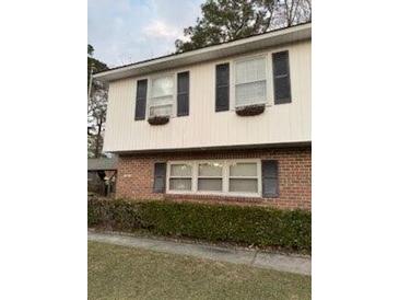 Two-story house with brick and vinyl siding, featuring multiple windows and landscaping at 1972 Green Park Ave, Charleston, SC 29414