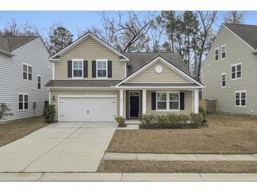Two-story house with beige siding, black shutters, and a white garage door at 9991 Winged Elm St, Ladson, SC 29456