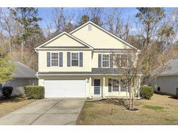Two-story yellow house with a white garage door and dark shutters at 114 Avalon Rd, Summerville, SC 29483
