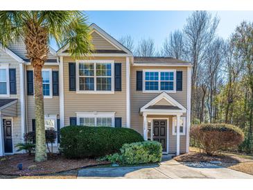 Tan two-story house with dark shutters, landscaping, and a driveway at 1295 Island Club Dr # E, Charleston, SC 29492