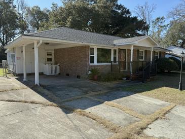 Brick ranch house with carport, mature trees, and a landscaped yard at 4765 S Constellation Dr, North Charleston, SC 29418