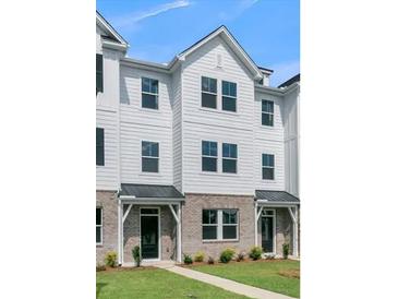 Three-story townhome with white siding, gray roof, and brick accents at 5112 Double Eagle, Summerville, SC 29485
