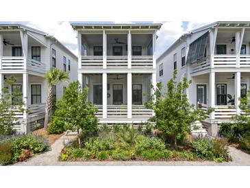 Charming white two-story home featuring a screened porch and landscaped front yard at 1474 Mizzen Aly, Johns Island, SC 29455