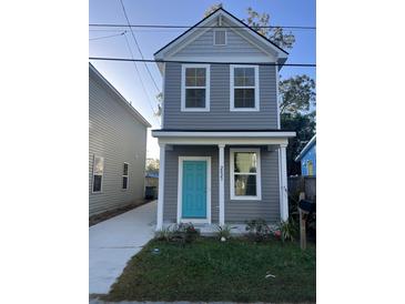 Two-story gray house with teal door, landscaping, and a paved driveway at 2023 Comstock Ave, North Charleston, SC 29405