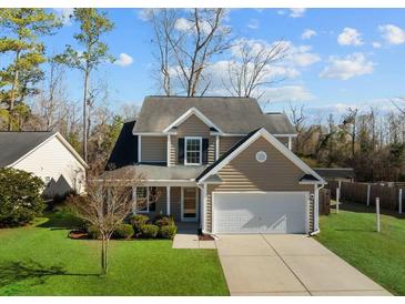 Two-story house with tan siding, a white garage door, and a well-manicured lawn at 2035 Culloden Dr, Summerville, SC 29483